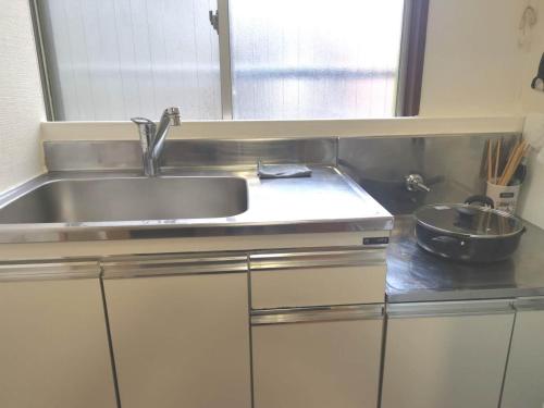 a kitchen with a sink and a bowl on a counter at HouseKL in Tokyo