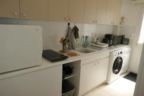 a kitchen with a sink and a washing machine at Gîte 2 pers en studio indépendant chez l'habitant pour nuitée au calme et proche de la plage in Saint-Georges-de-Didonne