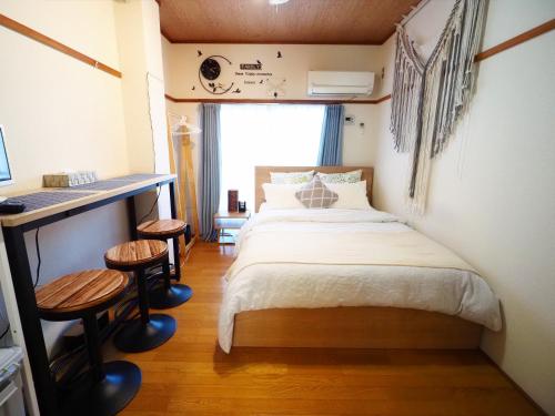 a bedroom with a bed and a desk and stools at 203 Near Koiwa st Airport Disney Direct Bus Max3人 in Tokyo