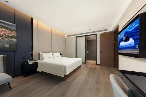 a bedroom with a bed and a flat screen tv at Atour Hotel Xiamen Guanyinshan East Huandao in Xiamen