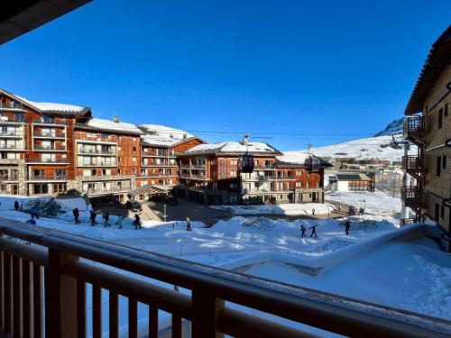 un groupe de personnes patinant sur une patinoire dans la neige dans l'établissement Homency - Résidence L'Expression B12, à L'Alpe-d'Huez