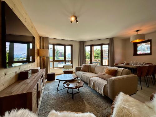 un salon avec un canapé et une table dans l'établissement Homency - Résidence L'Expression B12, à L'Alpe-d'Huez