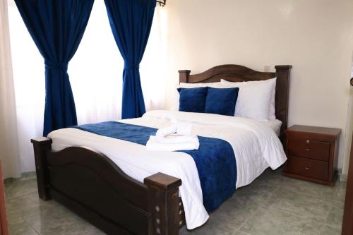 a bedroom with a large bed with blue curtains at Hotel San Lorenzo Ubaté in Ubaté