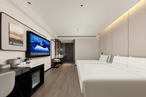 a hotel room with two beds and a flat screen tv at Atour Hotel Xiamen Guanyinshan East Huandao in Xiamen