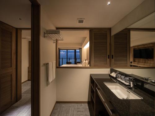 a bathroom with a sink and a window at Best Western Okinawa Kouki Beach in Nago