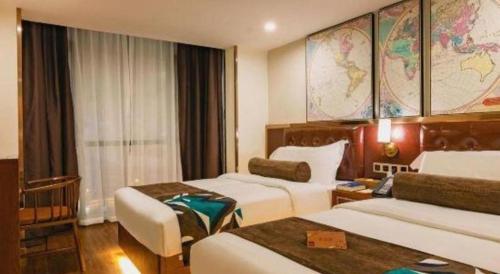 a hotel room with two beds and a desk at James Joyce Coffetel Guilin Railway Station Xiangbi Mountain Liangjiang Sihu Wharf in Guilin