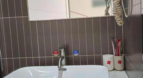 a bathroom with a sink and a mirror at Thank Inn Plus Hotel Guangdong Yunfu Luoding City Municipal in Yunfu