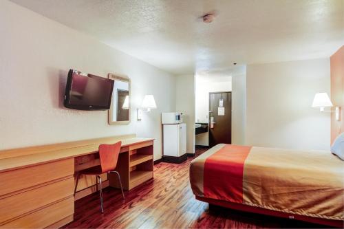 a hotel room with a bed and a desk with a television at Motel 6-Columbia, MO - East in Columbia