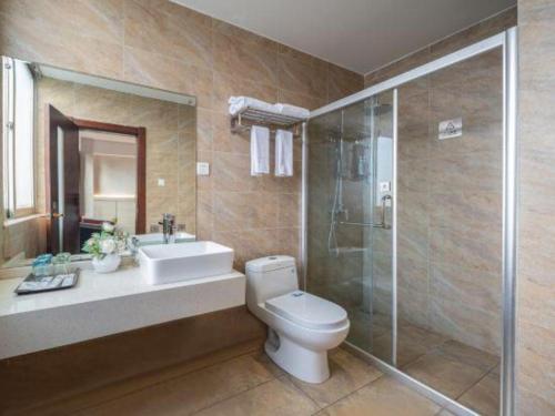 a bathroom with a toilet and a shower and a sink at Borrman Hotel Yuxi Yuxing Road in Yuxi