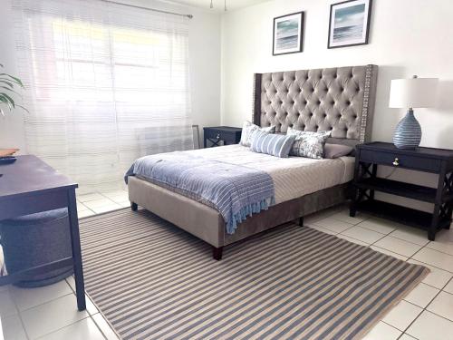 a bedroom with a large bed and a desk at Designer's 1 BR 1BA Condo 1 Block to Aventura Mall in Aventura