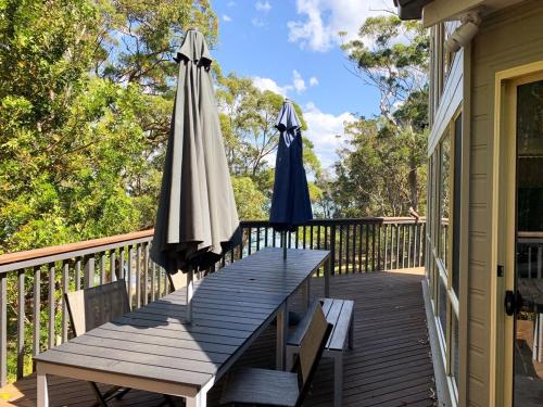 two umbrellas and a table on a deck at The Lake House on Amaroo in Smiths Lake