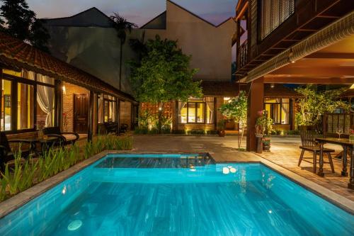una piscina en el patio trasero de una casa en DeMin Villa Hội An - Pool and BBQ Garden, en Hoi An