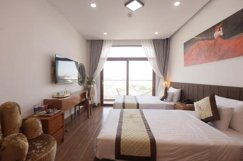 a hotel room with two beds and a television at Cát Tường Hotel in Da Lat