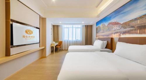 a hotel room with two beds and a flat screen tv at Vienna Hotel Guangdong Shantou South Bus Station in Shantou