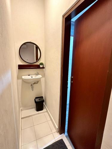 a bathroom with a sink and a mirror and a door at Simon Homestay in Sanur