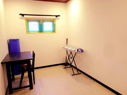 a room with a table and a stool and a window at Happy Three Holiday Homes in Hikkaduwa