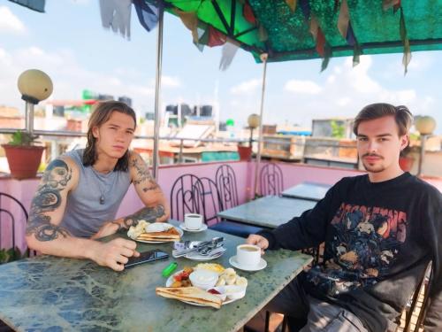 a man and woman sitting at a table eating food at HOTEL RUPAKOT AND ROOFTOP RESTAURANT in Bhaktapur