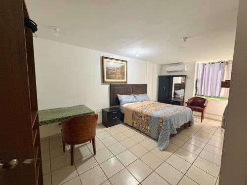 a bedroom with a bed and a table and a desk at Departamento Suite familiar frente a las riberas in Culiacán