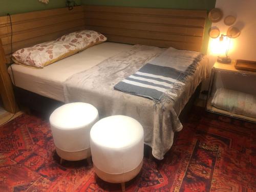a bedroom with a bed with three white stools at Studio equipado e decorado no Centro Balneário Camboriú in Balneário Camboriú