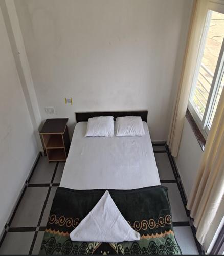 a bedroom with a bed with two pillows on it at CSR Palace Langasu By StayApart in Karnaprayāg
