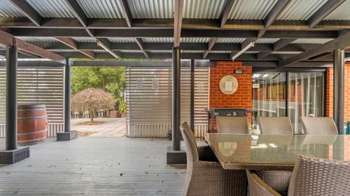 an outdoor patio with a glass table and chairs at McDougall Hidaway in Magpie
