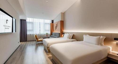a hotel room with two beds and a table at Airfeel Hotel in Ziyang