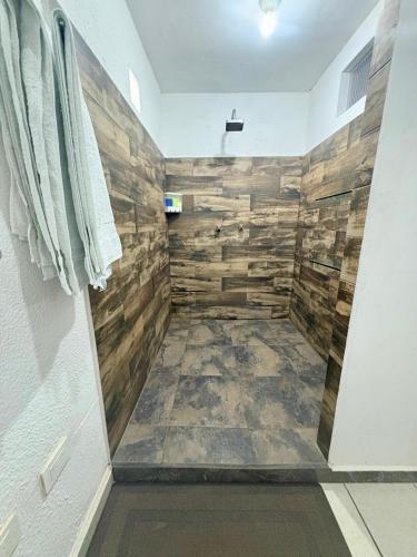 a bathroom with a shower with wooden walls at Departamento Suite familiar frente a las riberas in Culiacán