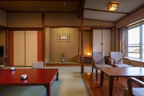 a living room with tables and chairs and a window at Fujiya in Niigata