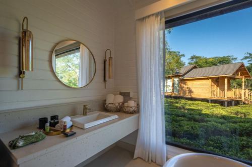 a bathroom with a sink and a large window at The Postcard in the Durrung Tea Estate, Assam in Tezpur