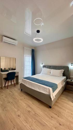 a bedroom with a large bed and a desk at MaRailiS Port Apart Mangalia in Mangalia