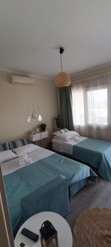 a hotel room with two beds and a table at Dream house Peramos in Nea Peramos