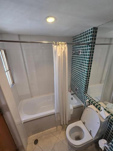a bathroom with a tub and a toilet and a shower at Riverside Bangkok Hotel in Bangkok