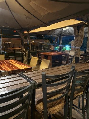 a restaurant with wooden tables and chairs and an umbrella at Departamento Suite familiar frente a las riberas in Culiacán