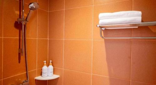 a bathroom with a shower with three bottles on a shelf at 777Bliss Hometel in Nakhon Phanom