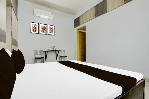 a bedroom with a bed and a table and chairs at Hotel O Happy Inn in Raipur
