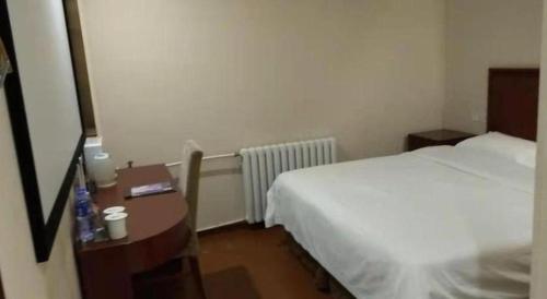 a hotel room with a bed and a desk with a bed sqor at GreenTree Inn Beijing East Yizhuang District Second Kechuang Street Express Hotel in Beijing
