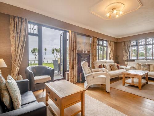 a living room with furniture and a large window at Beachside House in Scratby