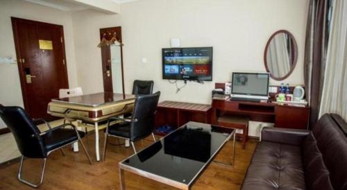 a living room with a couch and a table with chairs at GreenTree Inn Luoyang Zhongzheng Street Express Hotel in Luoyang