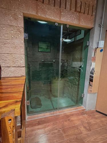 a large glass shower in a room with a wooden table at LOFT NUEVO EN MALECON FTE AL Parque las Riveras in Culiacán