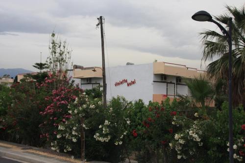 a building with a sign on the side of a street at Violetta Hotel in Amoudara Herakliou