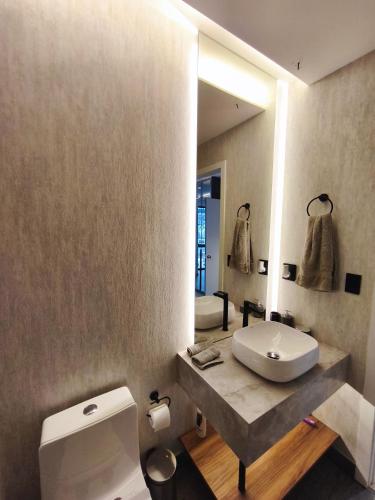 a bathroom with a toilet and a sink and a mirror at Republica del Salvador Coliving Ecuador XOE in Quito