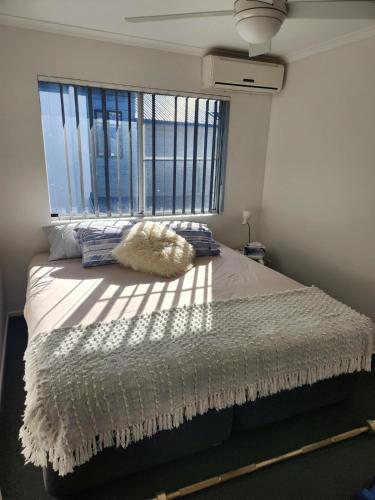 a bedroom with a bed with a large window at Canal Condo in Mooloolaba