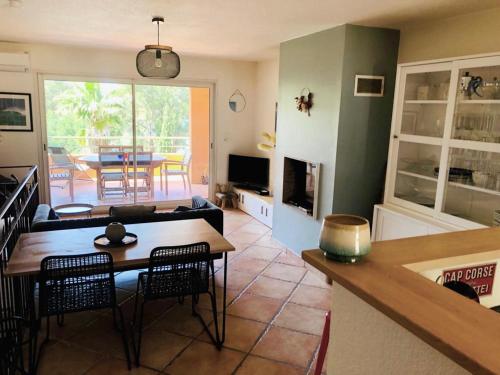 un salon avec un canapé, une table et des chaises dans l'établissement Les Palmiers - Saint Florent, à Saint-Florent