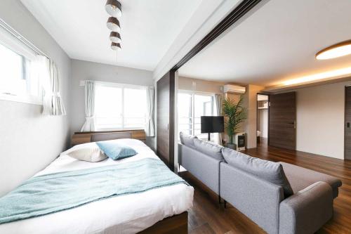 a bedroom with a bed and a couch at Twinberry CHITOSE in Chitose