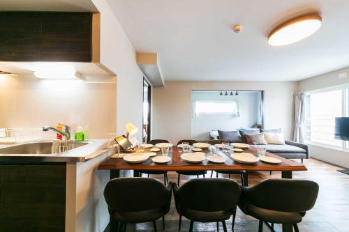 a kitchen and living room with a table and chairs at Twinberry CHITOSE in Chitose