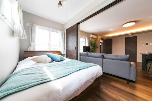 a bedroom with a large bed and a couch at Twinberry CHITOSE in Chitose