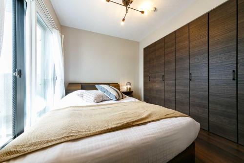 a bedroom with a large bed with a large window at Twinberry CHITOSE in Chitose