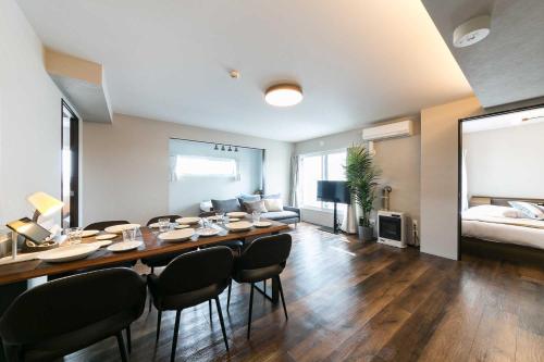 a living room with a table and chairs and a couch at Twinberry CHITOSE in Chitose