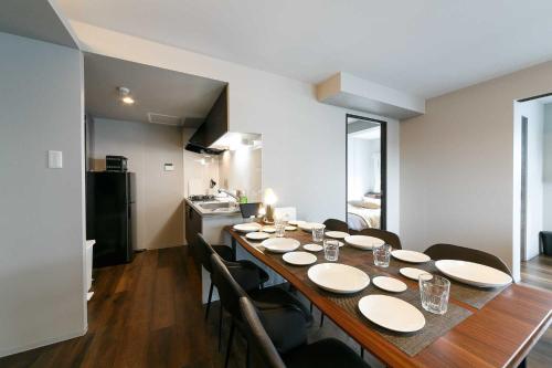 a dining room with a long table and chairs at Twinberry CHITOSE in Chitose