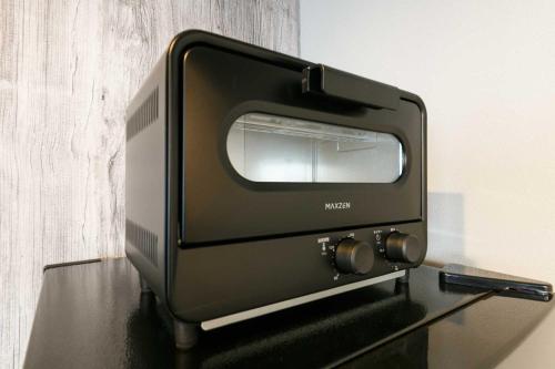 a black toaster oven sitting on top of a table at Twinberry CHITOSE in Chitose